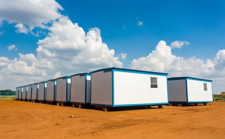 A complex of modern prefabricated buildings at a worksite.