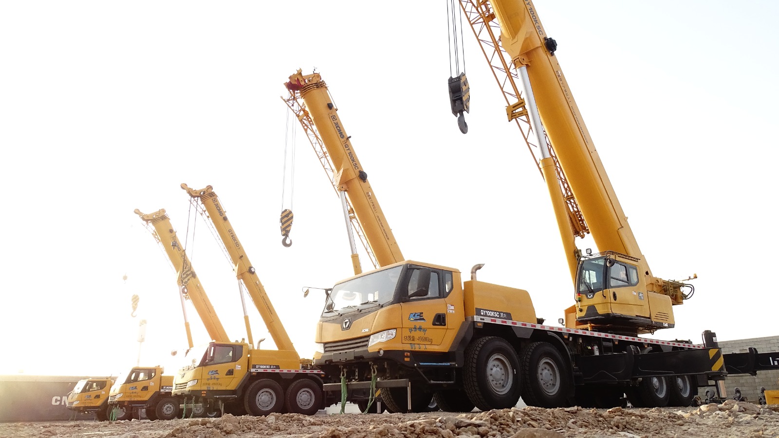 A dump truck unloading gravel at a large industrial site