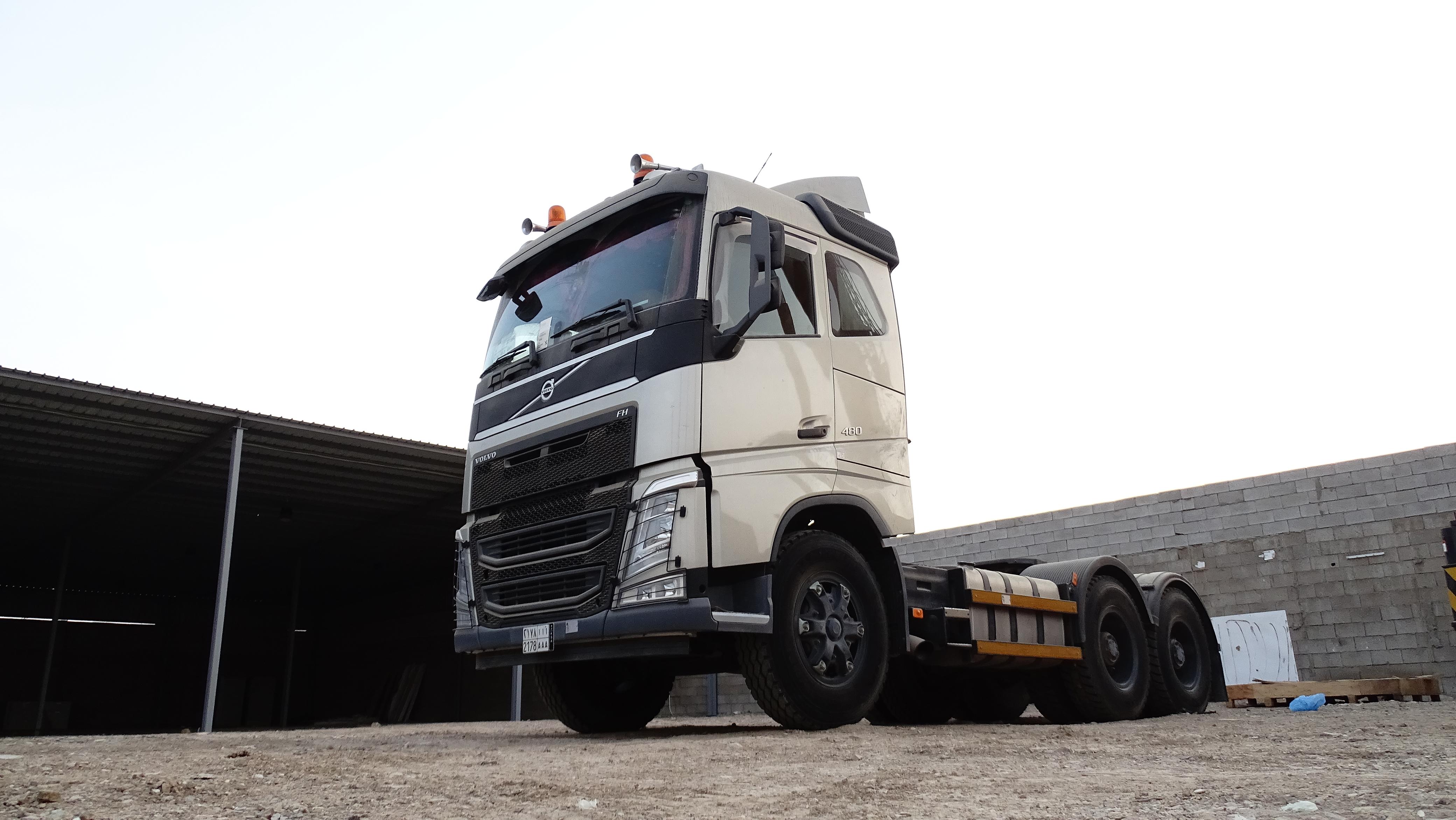 A fleet of various trucks parked at a logistics depot at dusk.